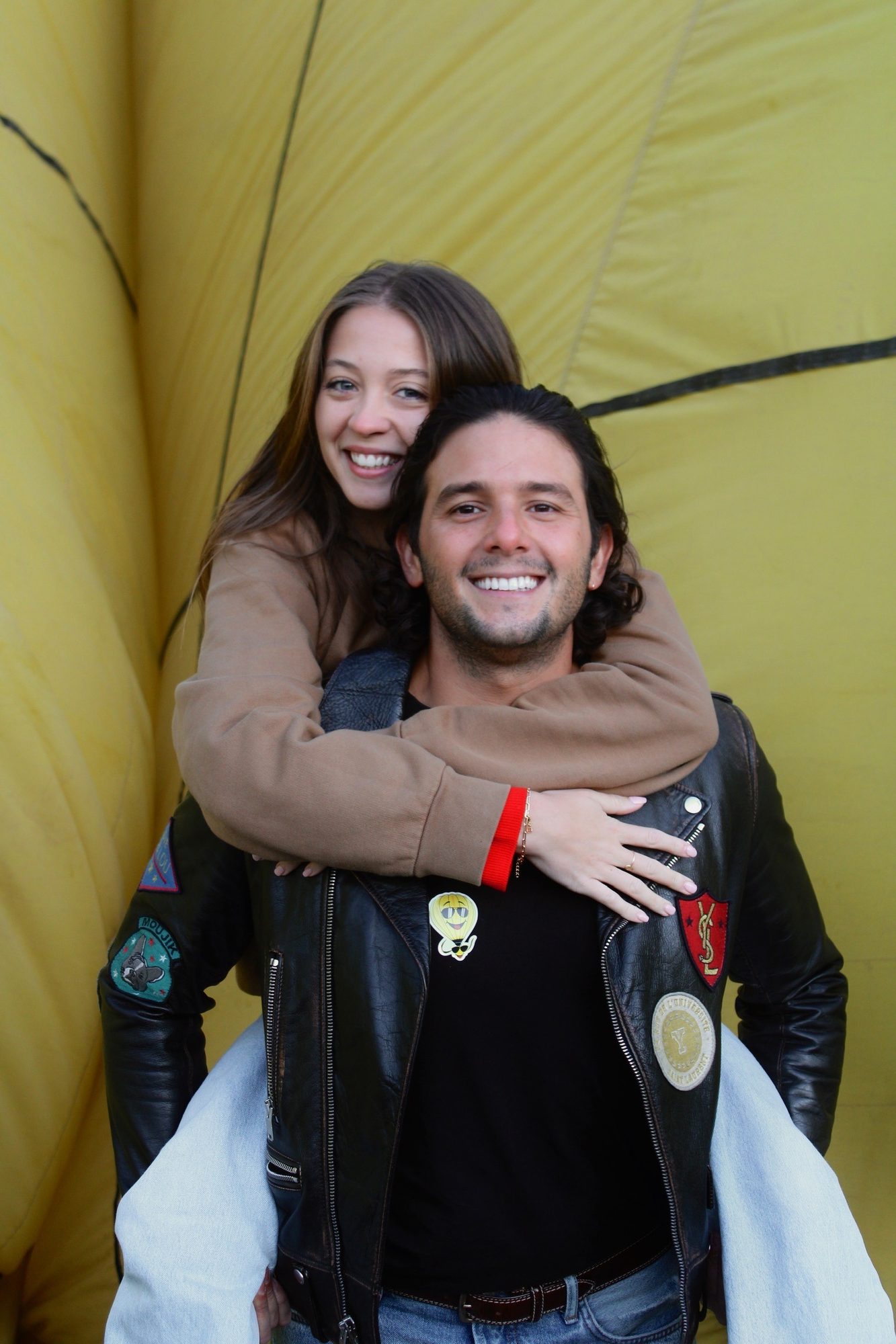 Pareja celebrando una pedida de mano frente al globo de Happy Puerto
